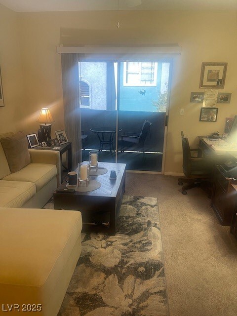 Carpeted living room featuring a desk