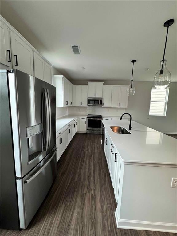 Kitchen featuring stainless steel appliances, a sink, light countertops, and white cabinets