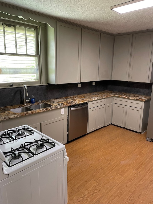 This kitchen features modern gray cabinetry, grani