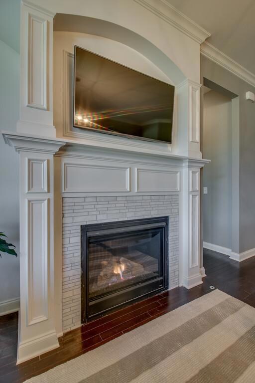 Gas fireplace is elegantly trimmed. Note the white marble tile surround. 