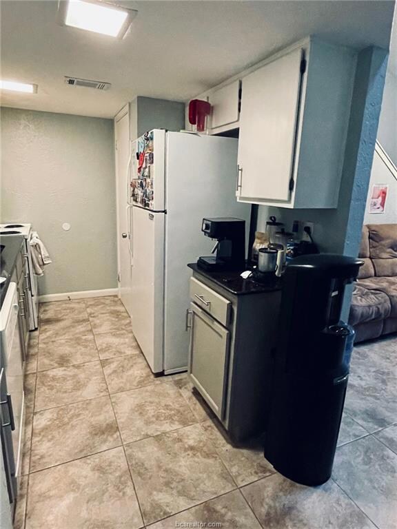 Kitchen with visible vents, electric stove, dark c