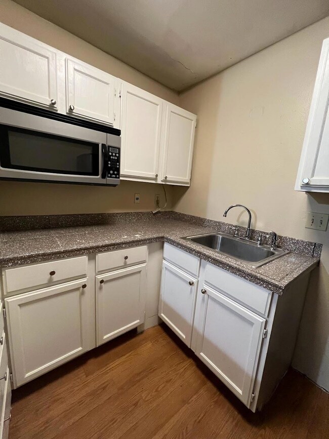Kitchen with white cabinets, a sink, stainless st