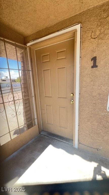 View of exterior entry featuring stucco siding