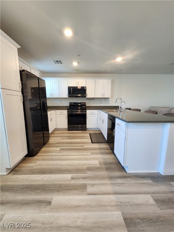 Kitchen featuring black appliances, dark counterto