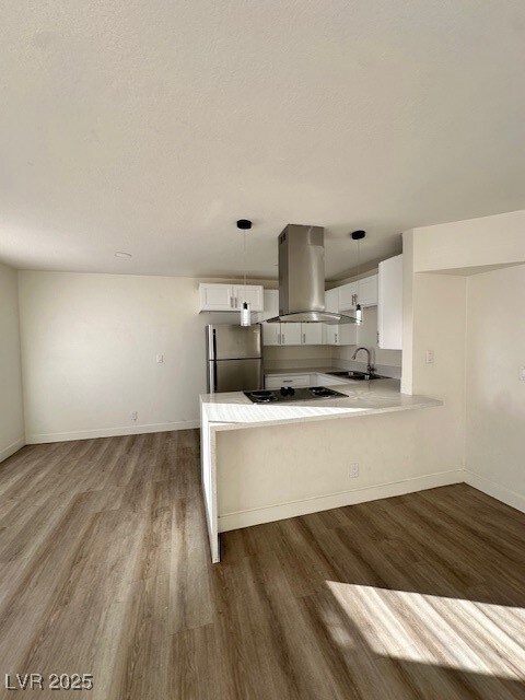 Kitchen featuring hanging light fixtures, white cabinetry, dark wood finished floors, and appliances with stainless steel finishes