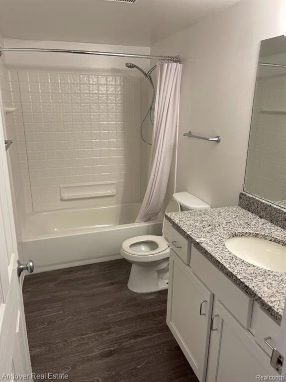 Full bath with vanity, dark wood finished floors, and shower / bath combination with curtain