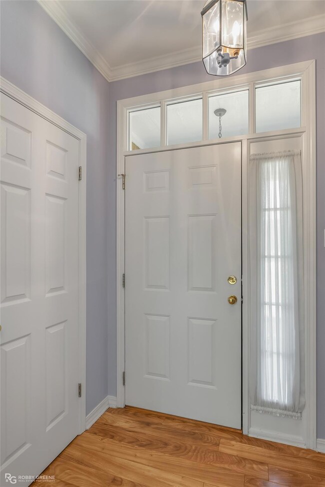 Entrance foyer featuring crown molding, a chandeli