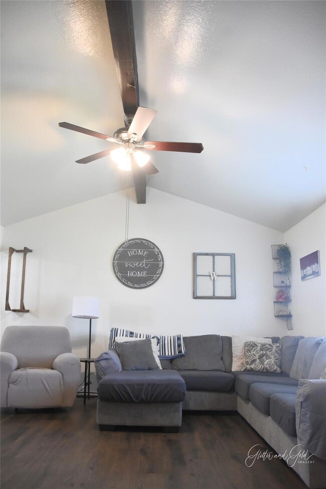 Living area featuring vaulted ceiling with beams, 