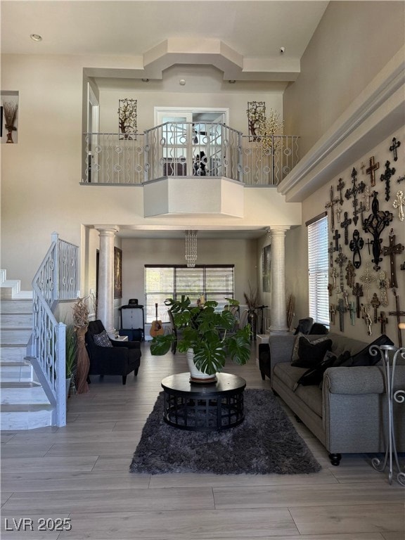 Living area with ornate columns, a high ceiling, w