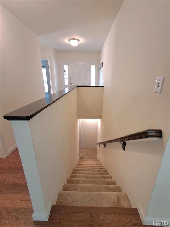 Stairs featuring wood finished floors and baseboards