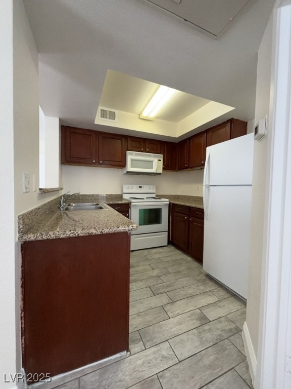 Kitchen with white appliances, wood finish floors