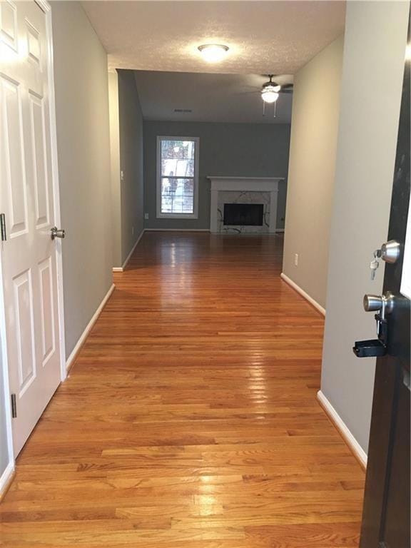 Hall featuring light wood-type flooring and baseboards