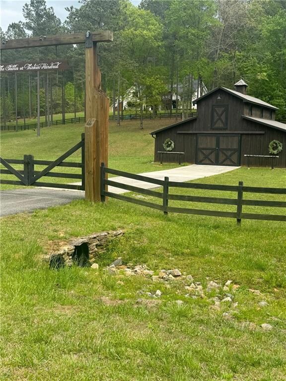 View of gate with a yard and an outdoor structure