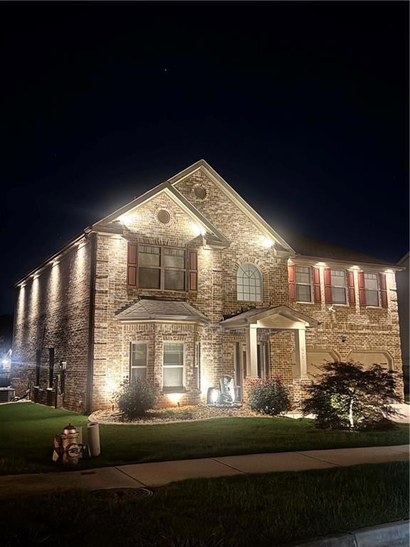 View of front facade featuring a yard and brick siding