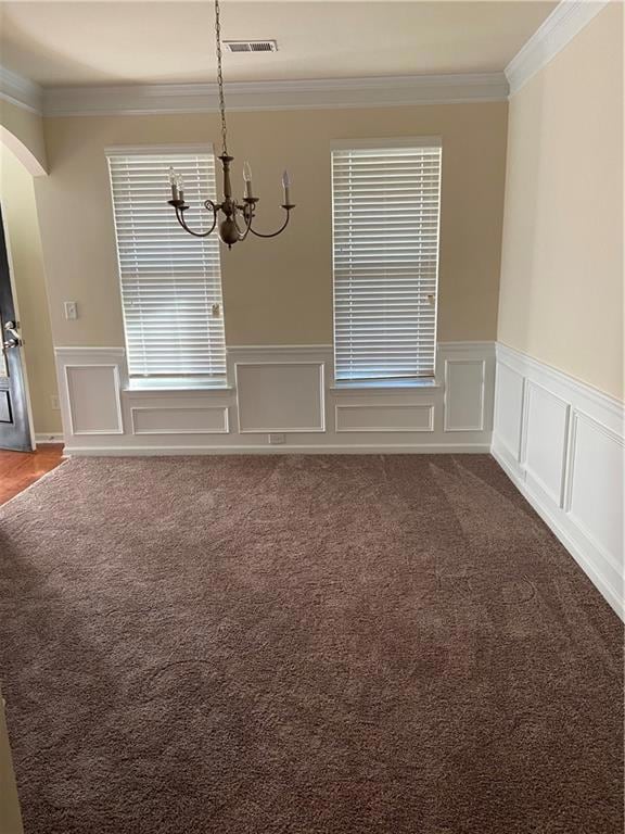 Empty room with a notable chandelier, carpet, and 