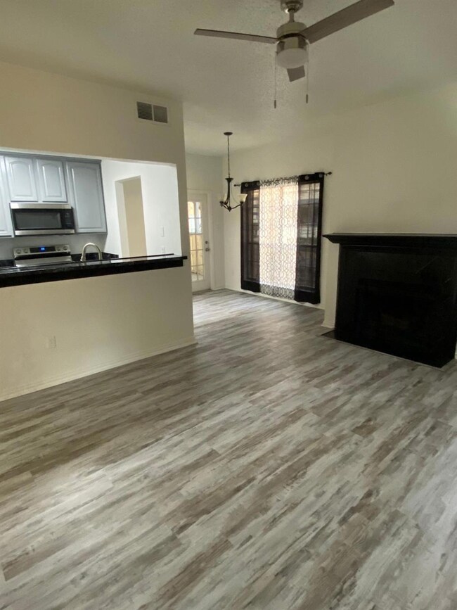 Unfurnished living room with ceiling fan with nota