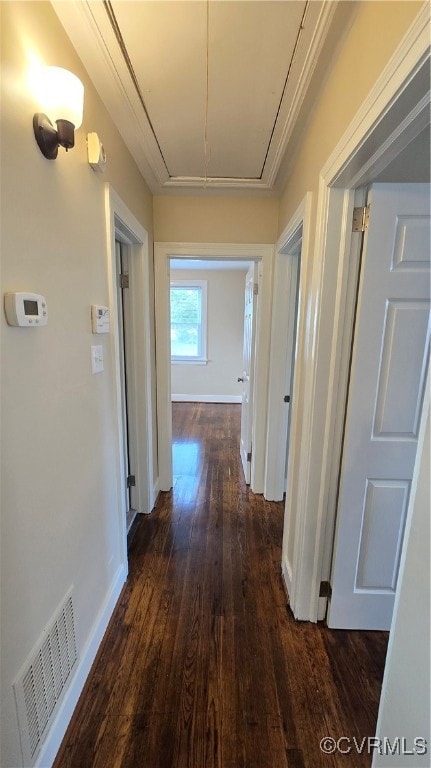 Hallway featuring attic access, dark wood-style fl