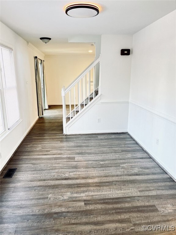 Unfurnished room with dark wood-type flooring