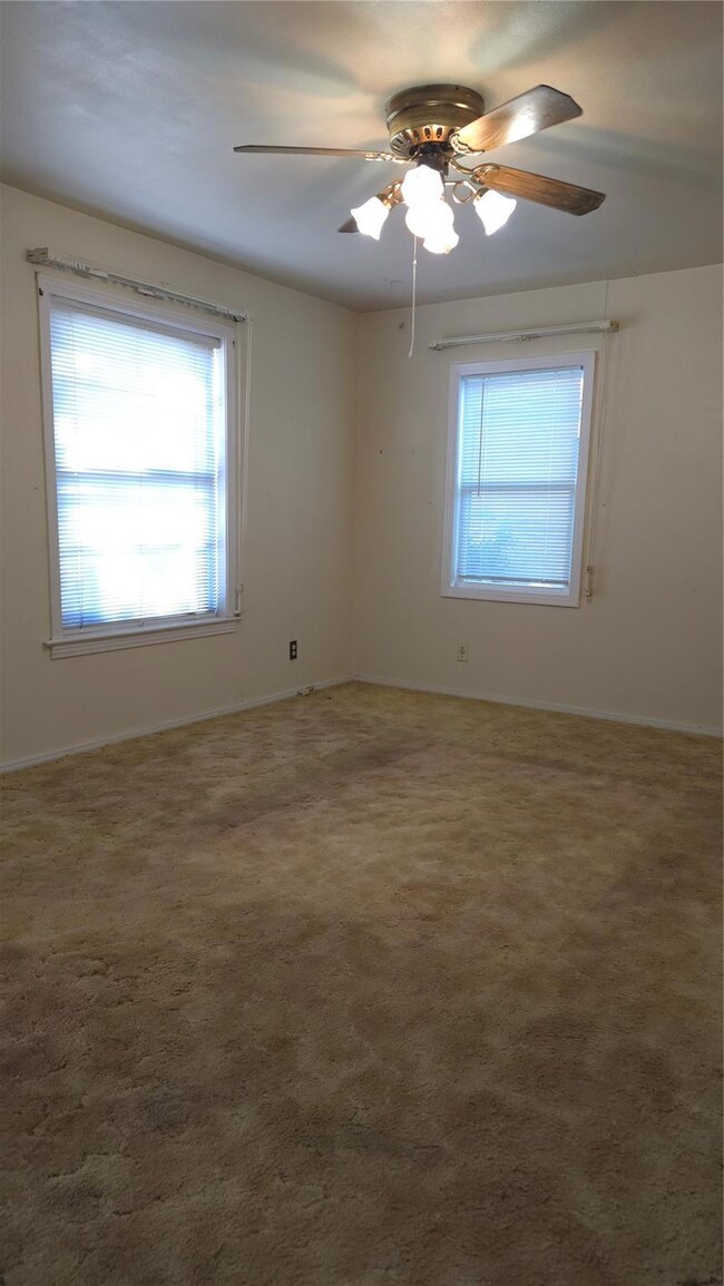 Carpeted living room featuring ceiling fan