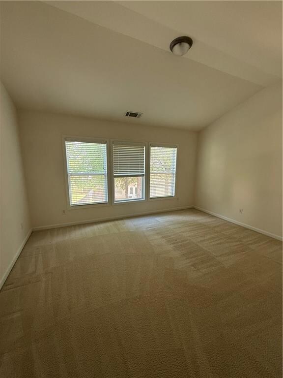 Spare room with baseboards and light carpet