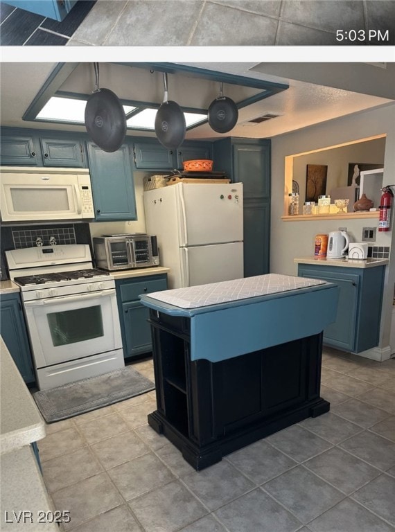 Kitchen with light countertops, a center island, b