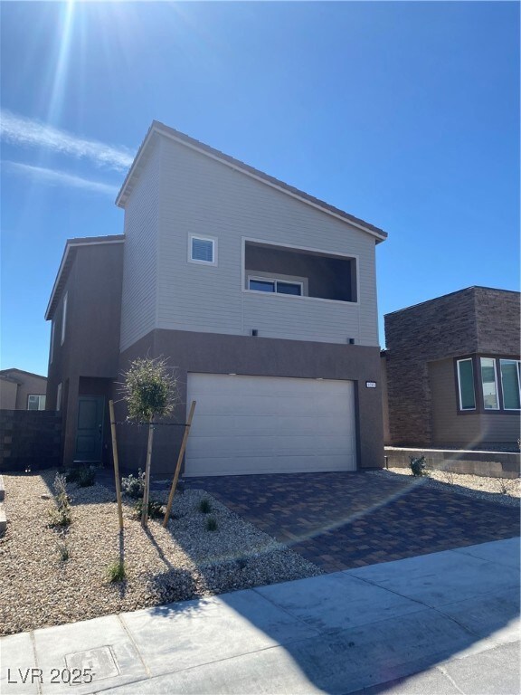 Modern home with decorative driveway, an attached