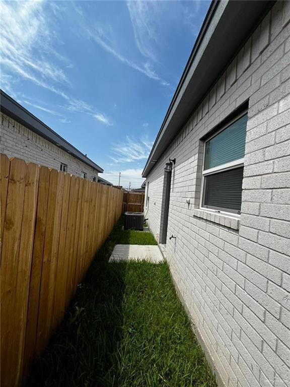 View of side of home featuring brick siding and a patio