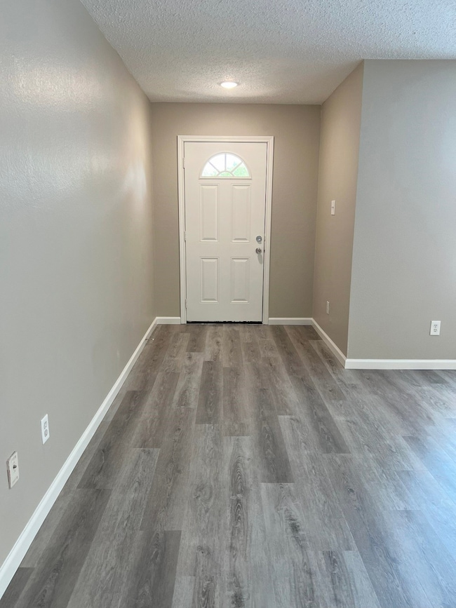Entrance foyer with a textured ceiling and wood finished floors