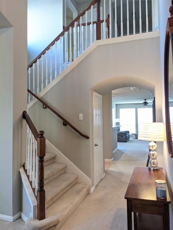 Open staircase off the entry with arches