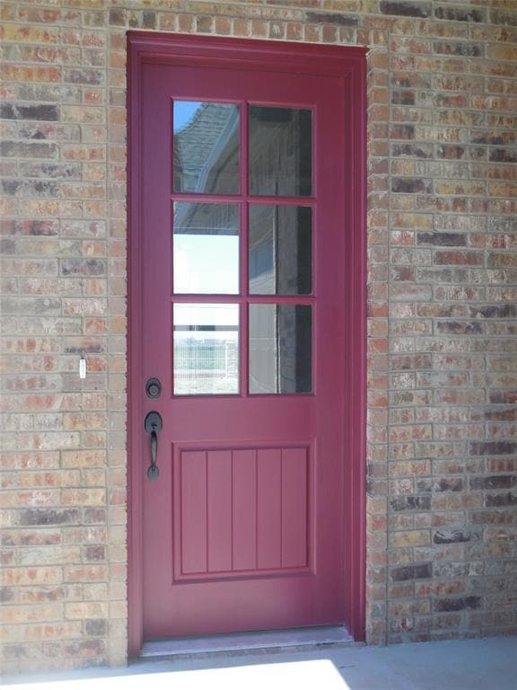 Doorway to property with brick siding