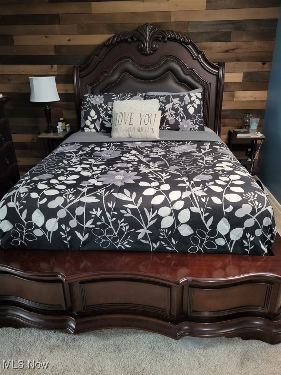 Carpeted bedroom with wood walls