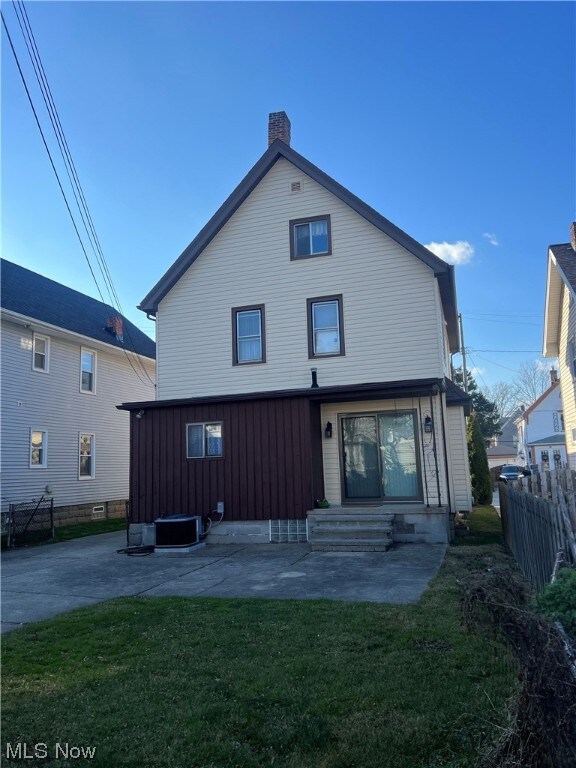 Rear view of property with a patio area and a lawn