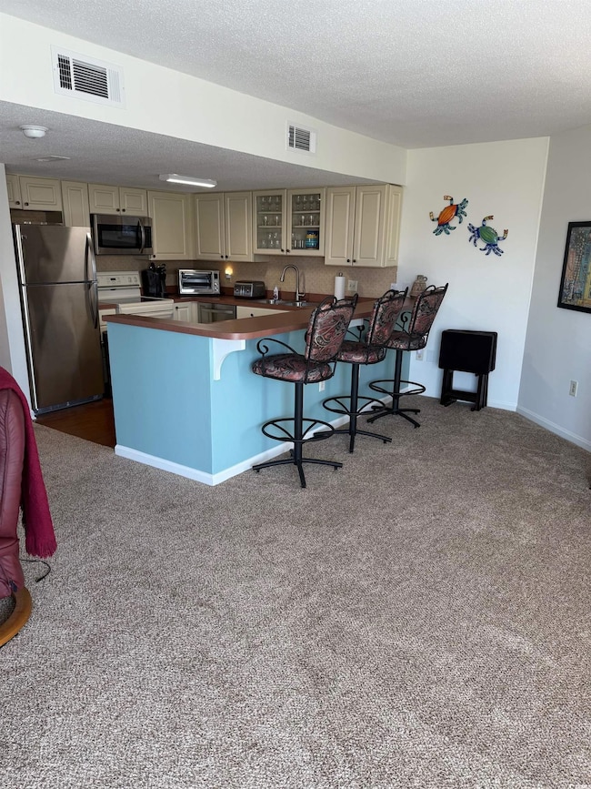 Kitchen featuring visible vents, cream cabinets, a