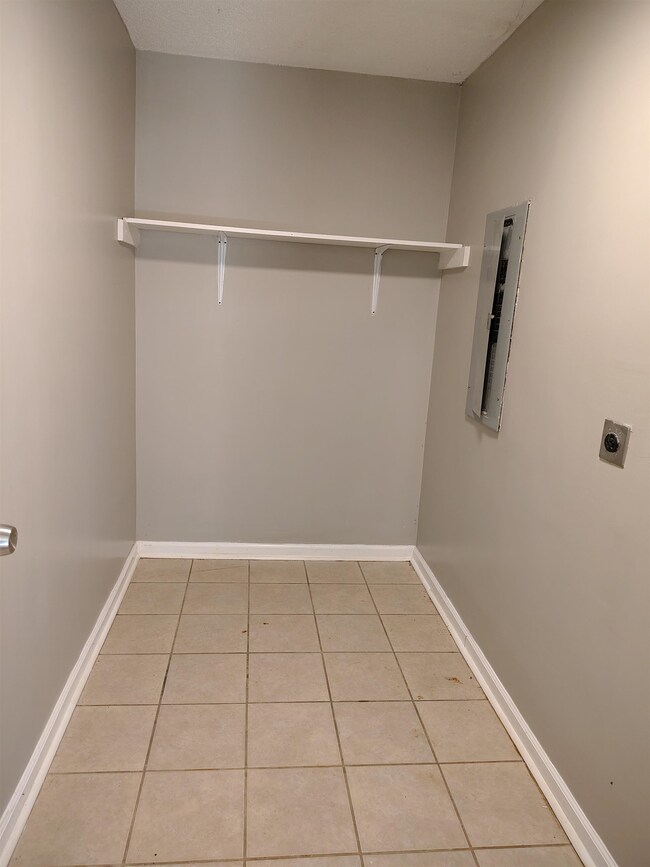 Walk in closet with electric panel and light tile 