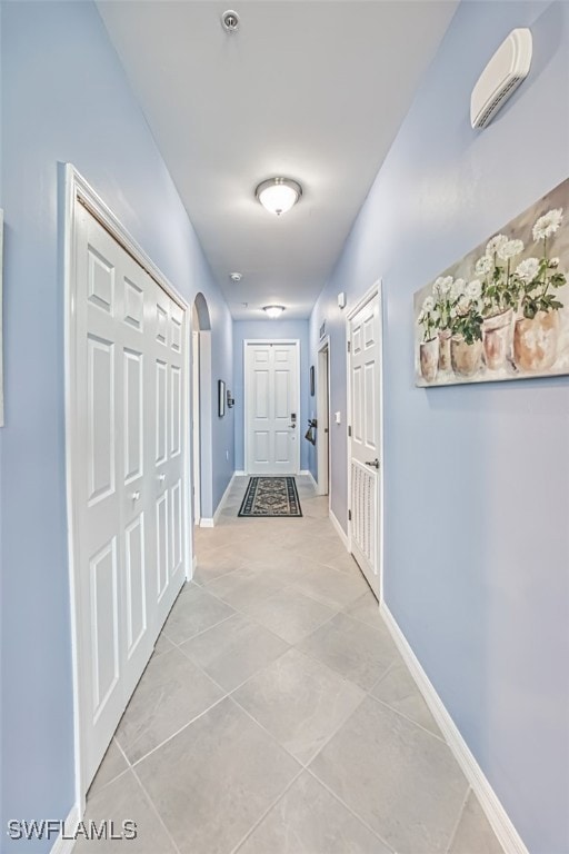 Corridor featuring light tile patterned floors, ar