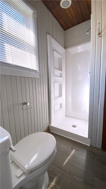 Bathroom featuring a stall shower, toilet, wood wa