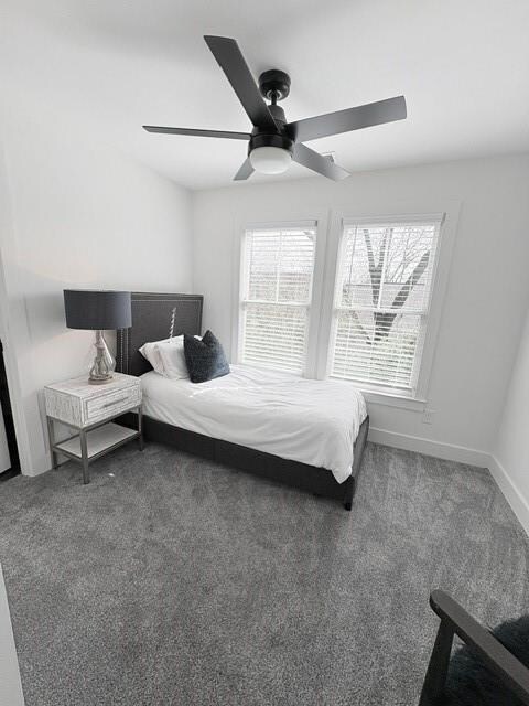Carpeted bedroom featuring ceiling fan and baseboa