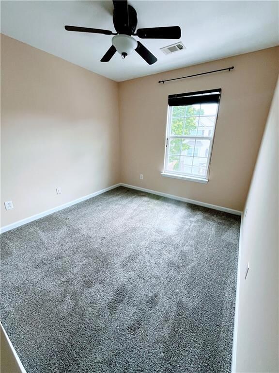 Unfurnished room with baseboards, ceiling fan, car