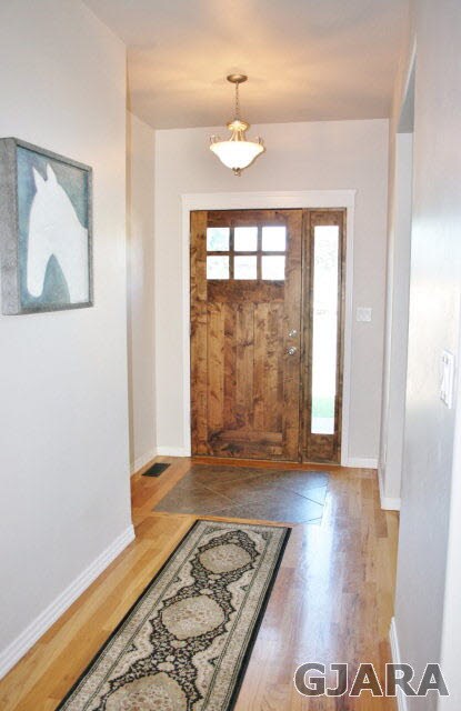 Entry inlaid tile in hardwood flooring.