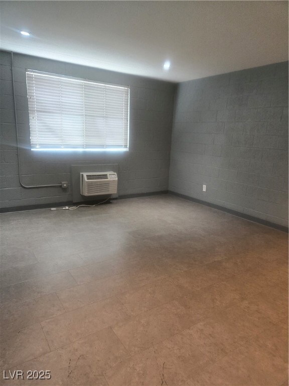 Empty room with concrete block wall, a wall mounte