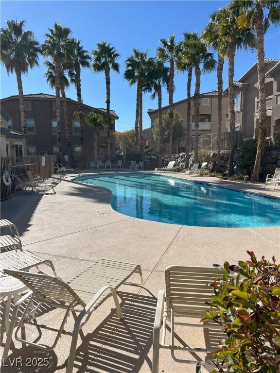 Community pool featuring fence and a patio area