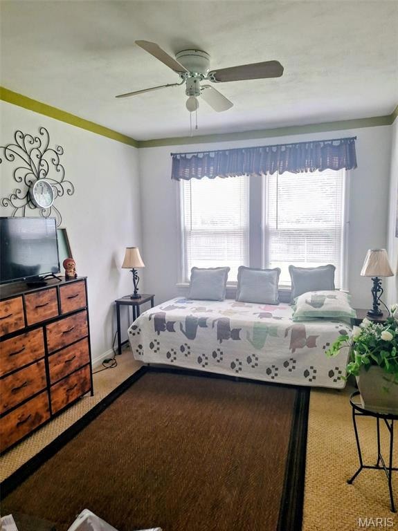 Bedroom featuring multiple windows, carpet floors, and a ceiling fan