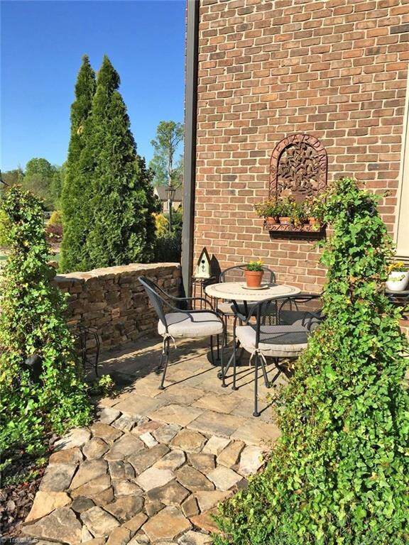 The front of the home showcases a private, beautifully landscaped bistro patio that is perfect for entertaining neighbors on a beautiful spring day.