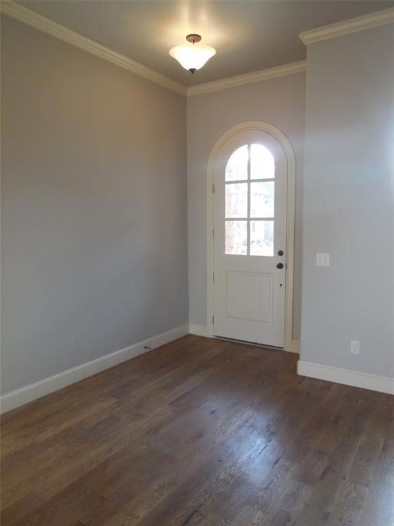 Entryway featuring ornamental molding, dark wood-style floors, and arched walkways