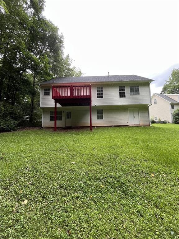 Back of property with a yard and a wooden deck