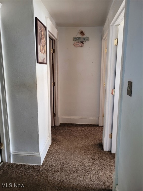 Corridor with carpet flooring and baseboards