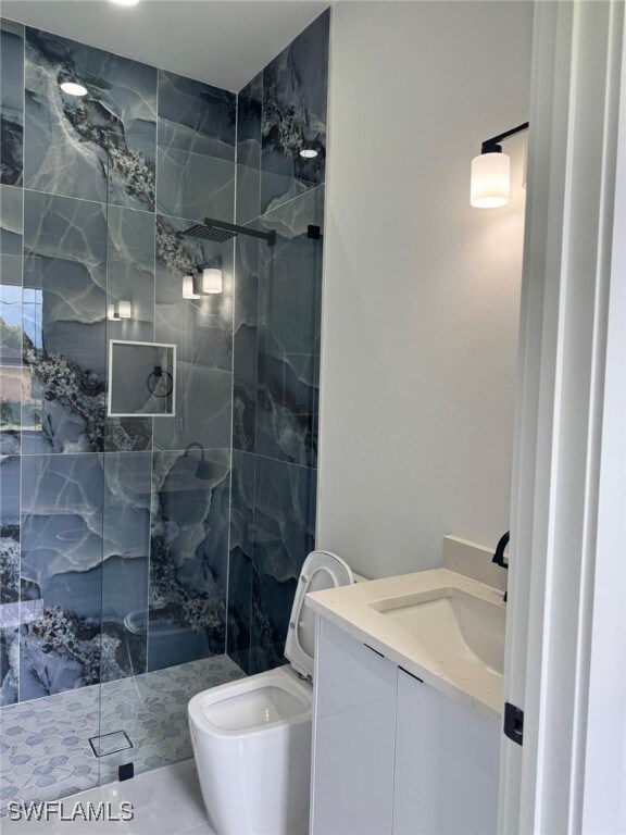 Bathroom featuring vanity and a marble finish show