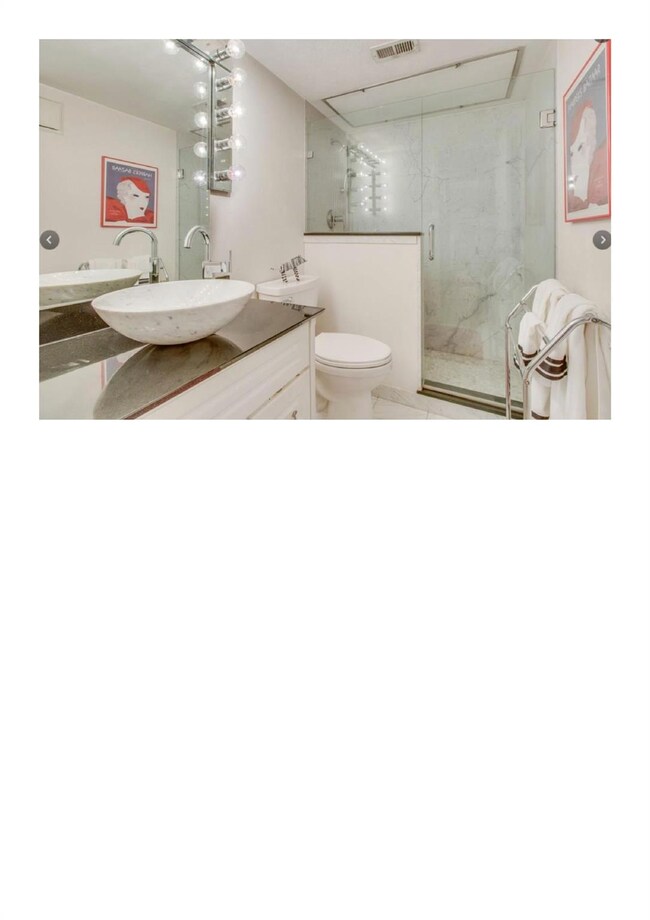 Bathroom with vanity, toilet, and a shower with door