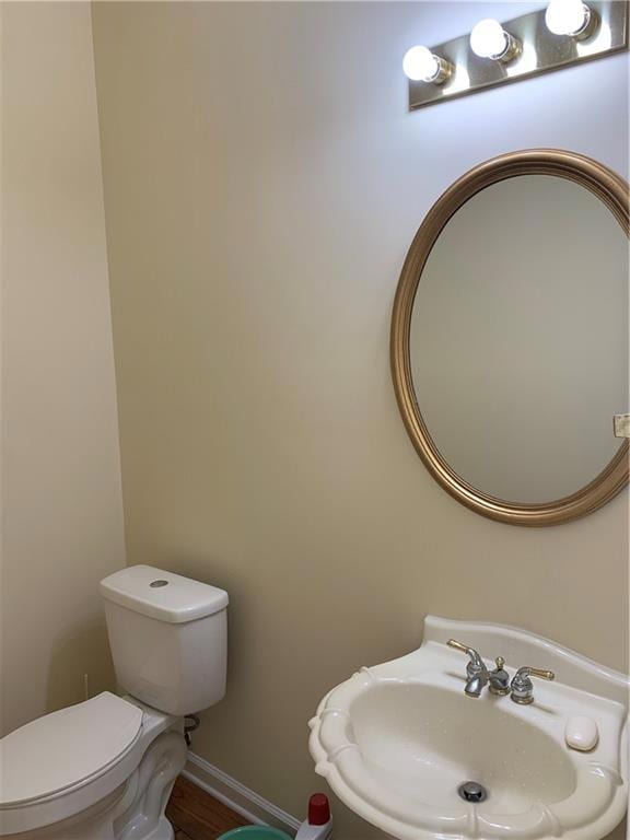 Bathroom featuring toilet, sink, and hardwood / wo