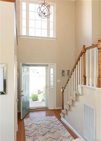 Bright 2 story foyer with updating lighting, wood floors and fresh neutral paint.